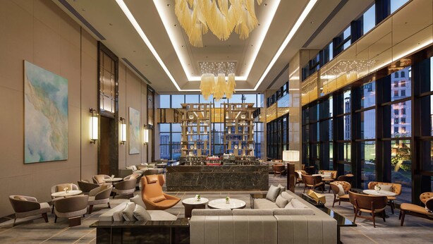 A spacious lobby with a central bar, comfortable seating, and large windows offering city views. - Doubletree by Hilton Yangzhou (Yangzhou)