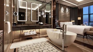 A modern hotel room with a large bed, a separate bathroom with a bathtub, and a large mirror with lights. - Doubletree by Hilton Yangzhou (Yangzhou)