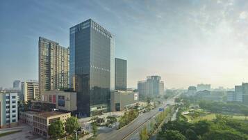 A modern urban landscape with high-rise buildings, a wide road, and green spaces.