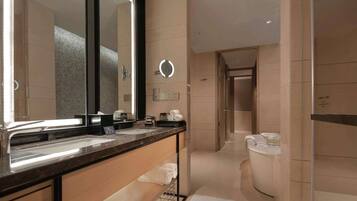 Un baño moderno con un espejo grande, lavamanos dobles y un inodoro.