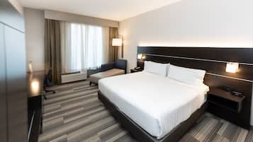 Une chambre d’hôtel moderne équipée d’un grand lit, d’un bureau, d’une chaise et d’une lampe de bureau.