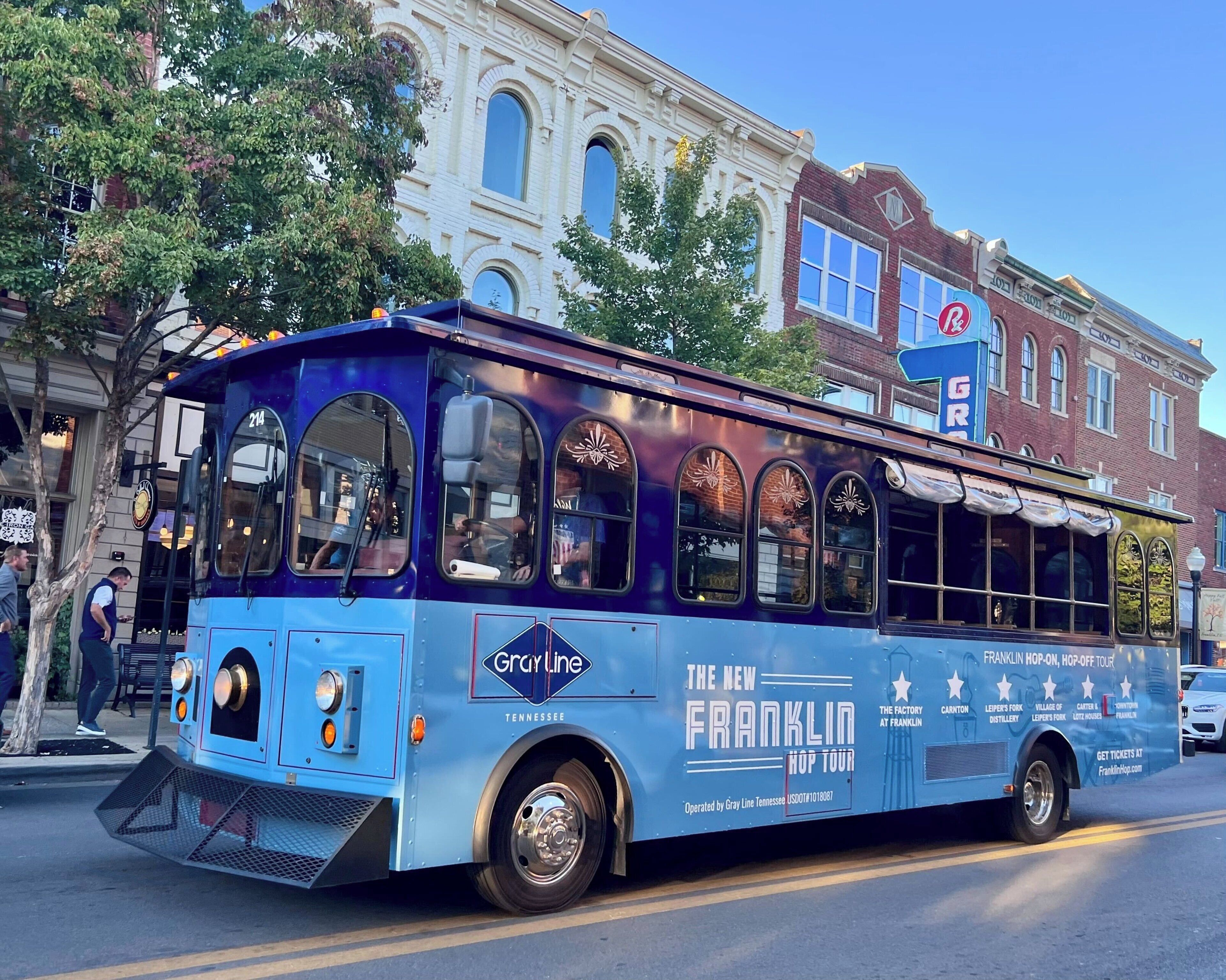 Un autobús turístico azul con la marca 