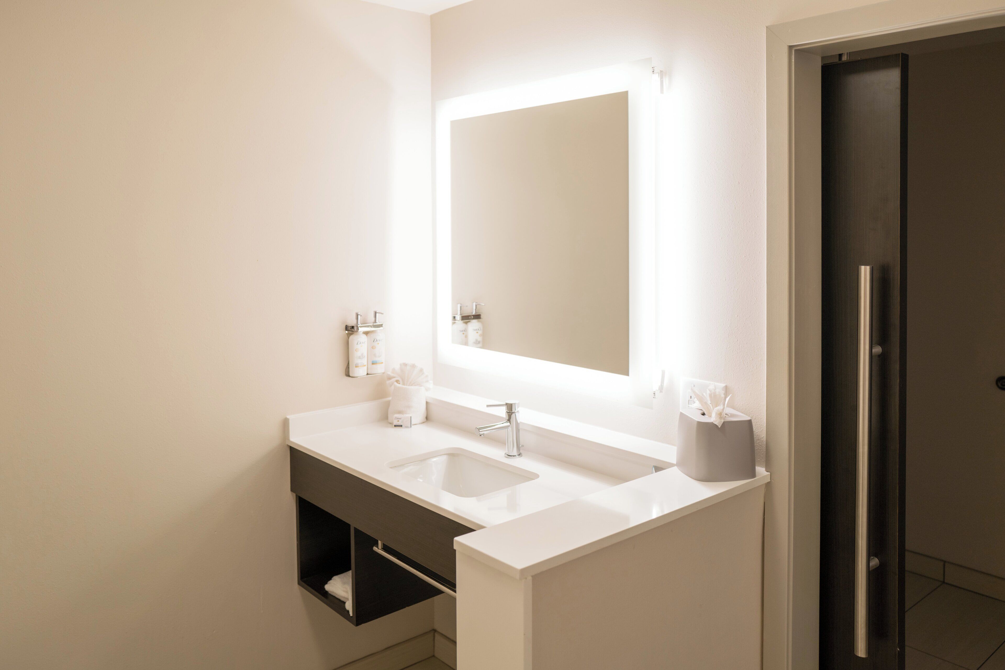 Un baño moderno con lavamanos doble, un espejo grande y un perchero para toallas.