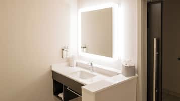 A modern bathroom with a double sink, a large mirror, and a towel rack.