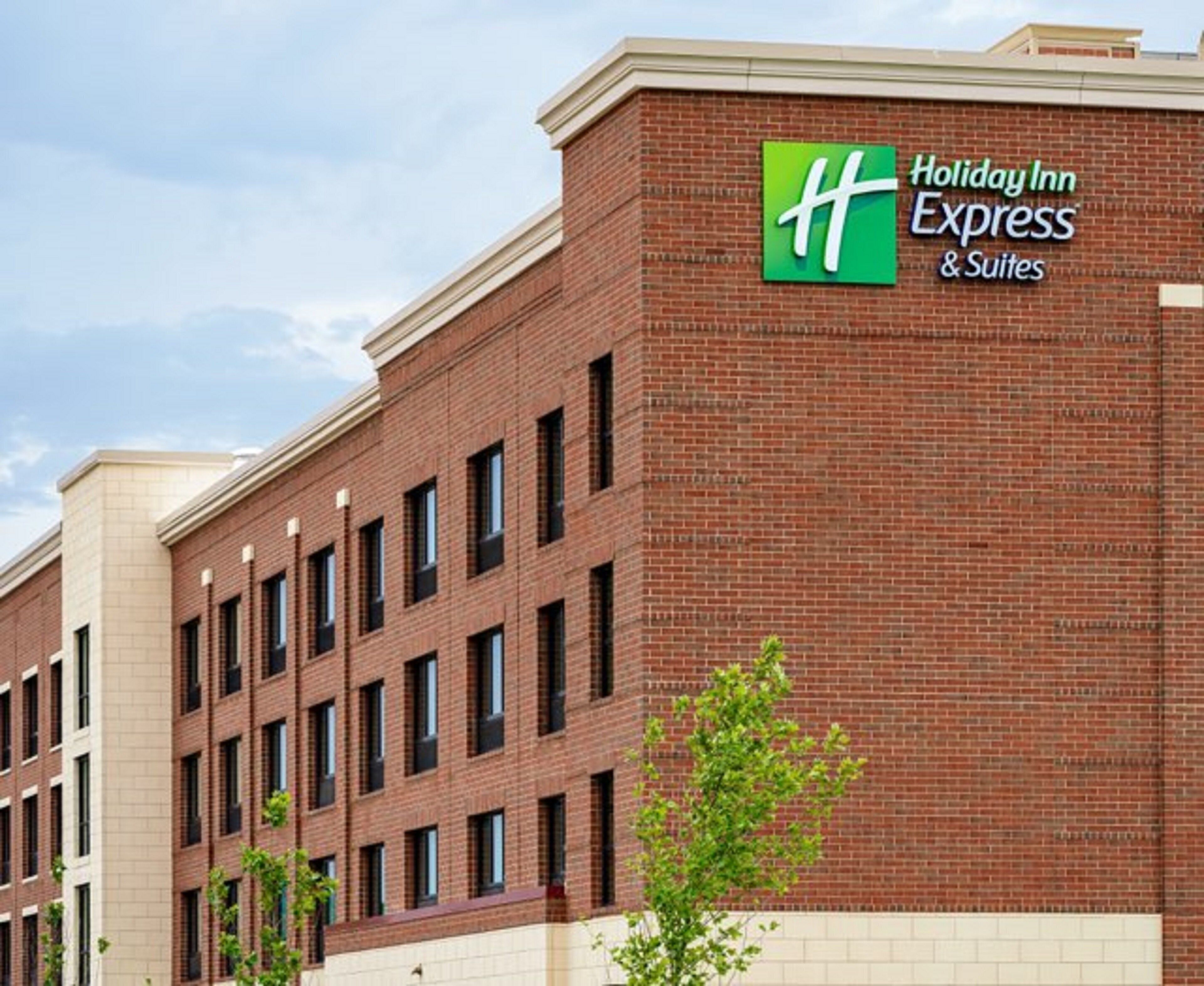En Holiday Inn Express & Suites bygning med facade i mursten og flere vinduer.