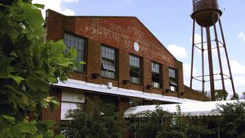 A historic brick building with a water tower labeled "The Factory at Franklin".