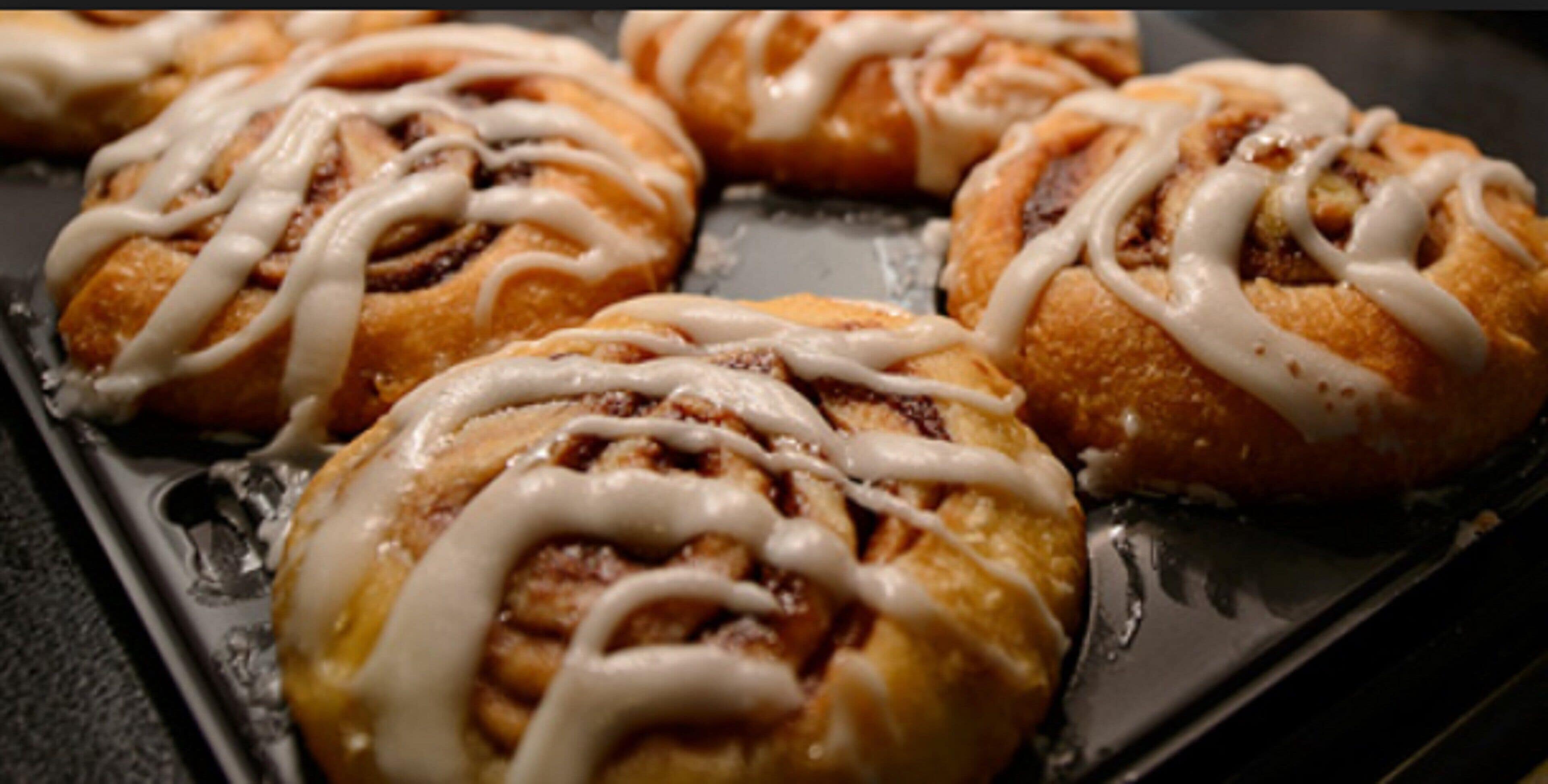 A tray of cinnamon rolls with icing.