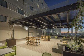 An outdoor terrace with tables and chairs, a covered seating area, and potted plants. - Holiday Inn & Suites Aguascalientes by IHG (Aguascalientes)