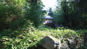A rustic cabin surrounded by dense forest. - Penalhuzet (Ronne)