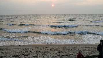 A beach with waves and a sunset.