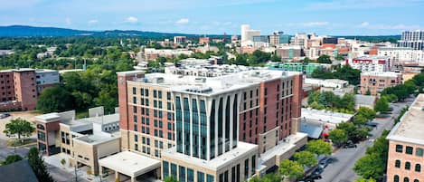 A multi-story building with a modern architectural design, featuring large windows and a flat roof.