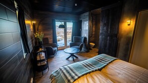 Une pièce confortable avec un lit, une petite table, une chaise et une bibliothèque.