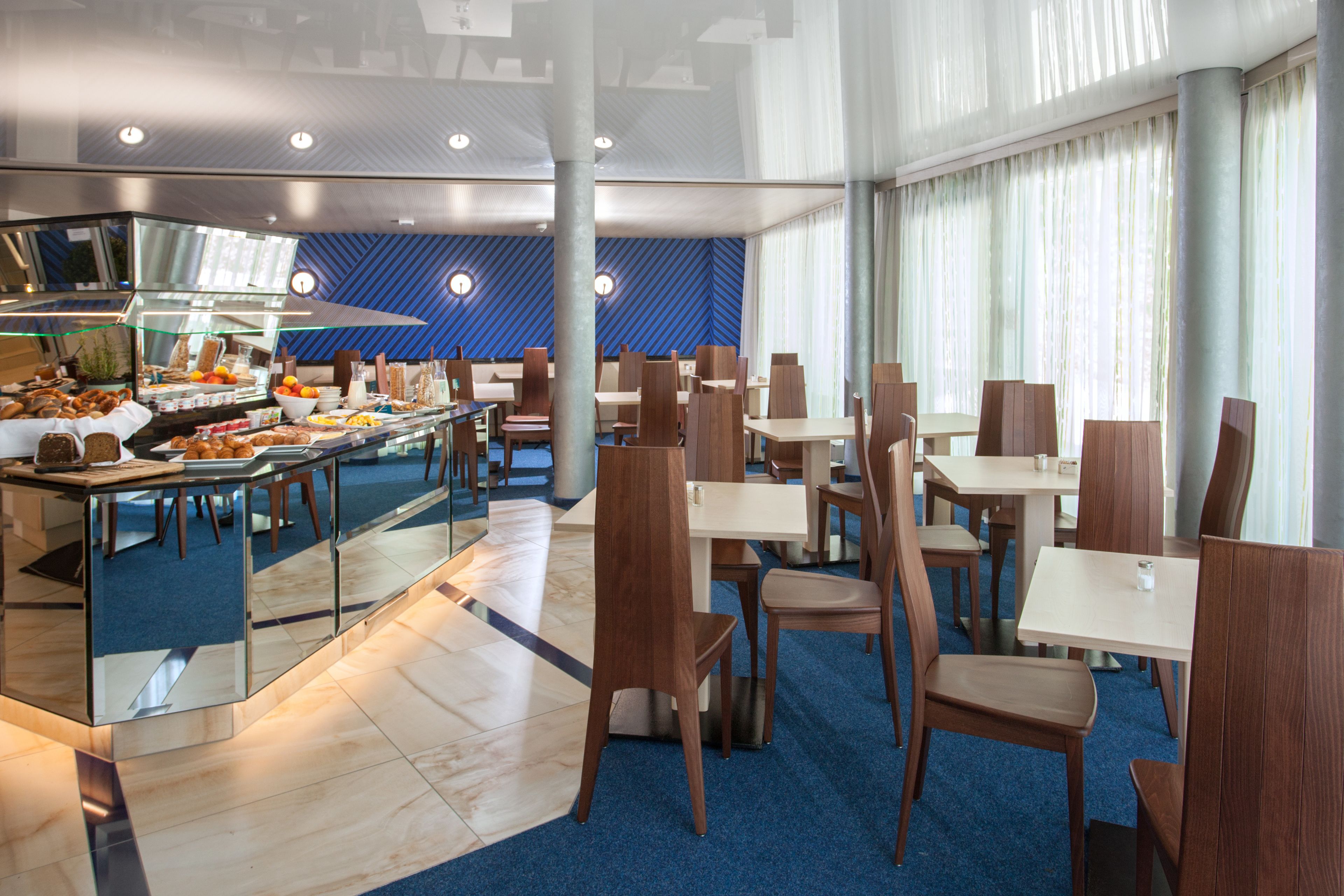 Ein moderner Essbereich mit Buffet, Holzkästen und einem blauen Teppich.