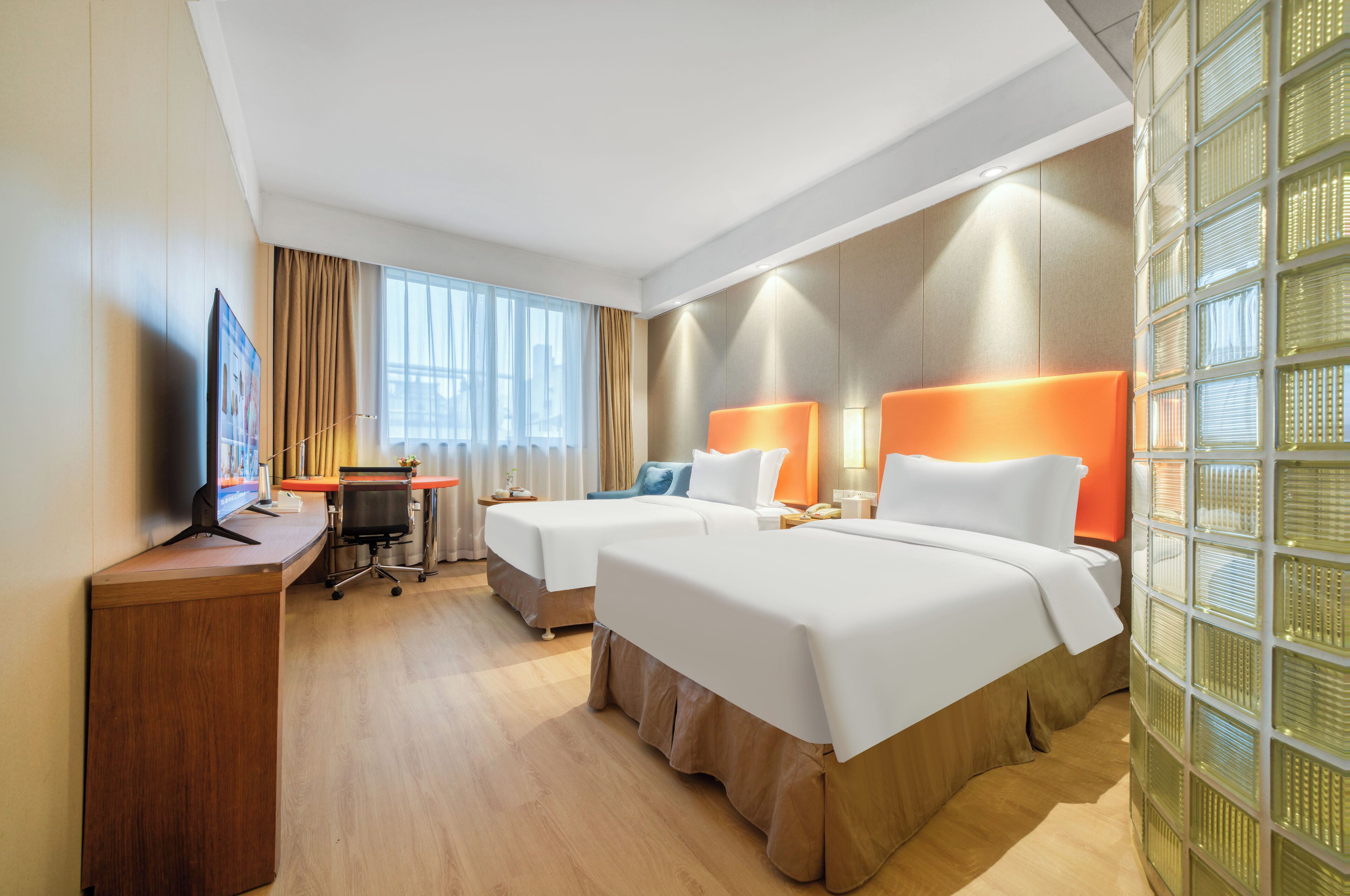 Habitación de hotel con dos camas, un escritorio y una computadora.