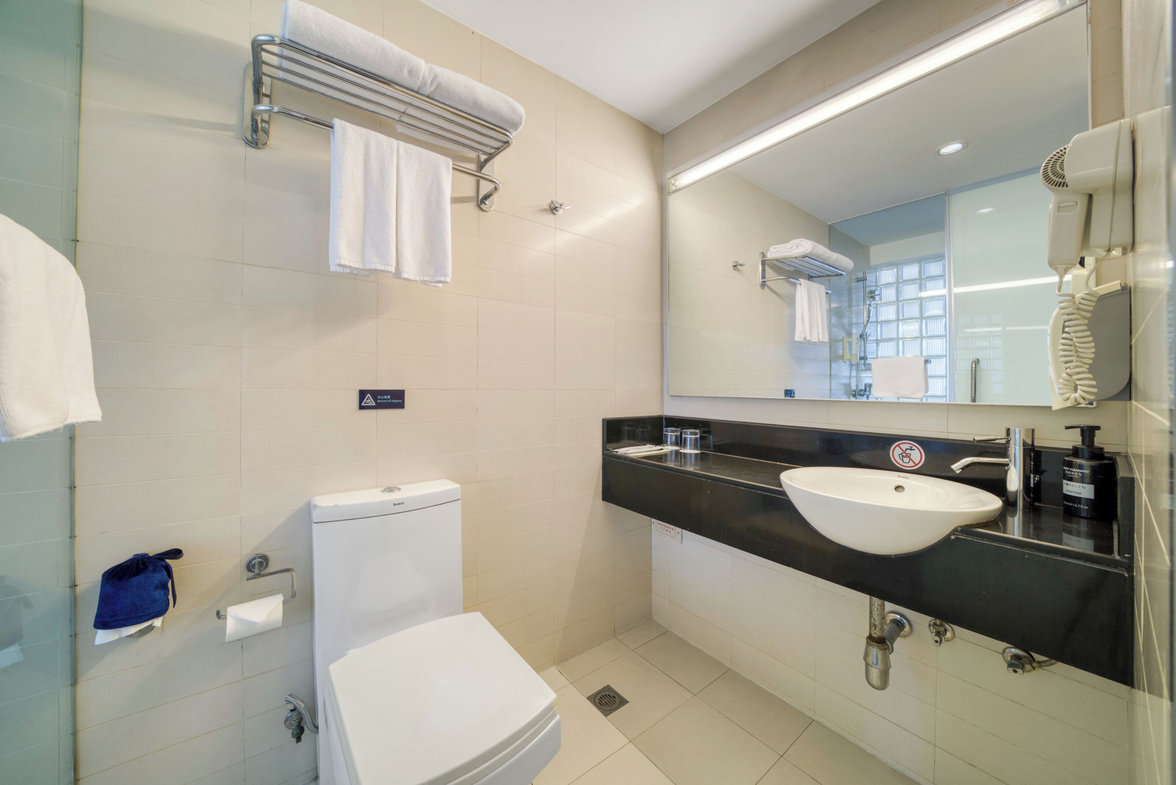 A modern bathroom with a toilet, sink, and towel rack.
