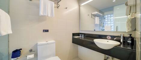 A modern bathroom with a toilet, sink, and towel rack.