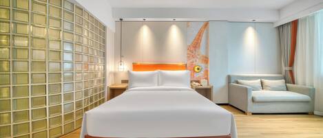 A hotel room with a large bed, a sofa, a wall with a geometric pattern, and a map artwork.