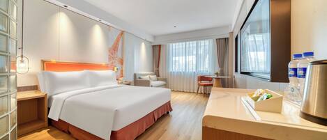 Habitación de hotel moderna con una cama grande, un escritorio, una silla y vistas a la ciudad.