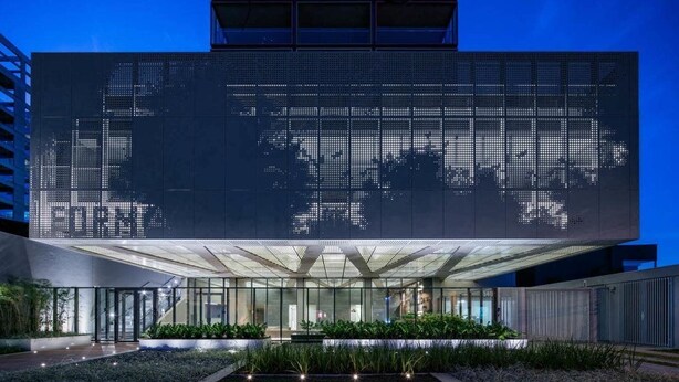 A modern building with a large digital display on the facade, a covered entrance, and landscaped areas with plants. - Forma Itaim by Q Apartments (São Paulo)