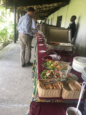 A buffet setup with various food items and utensils. - Momella Wildlife Lodge (Arusha)