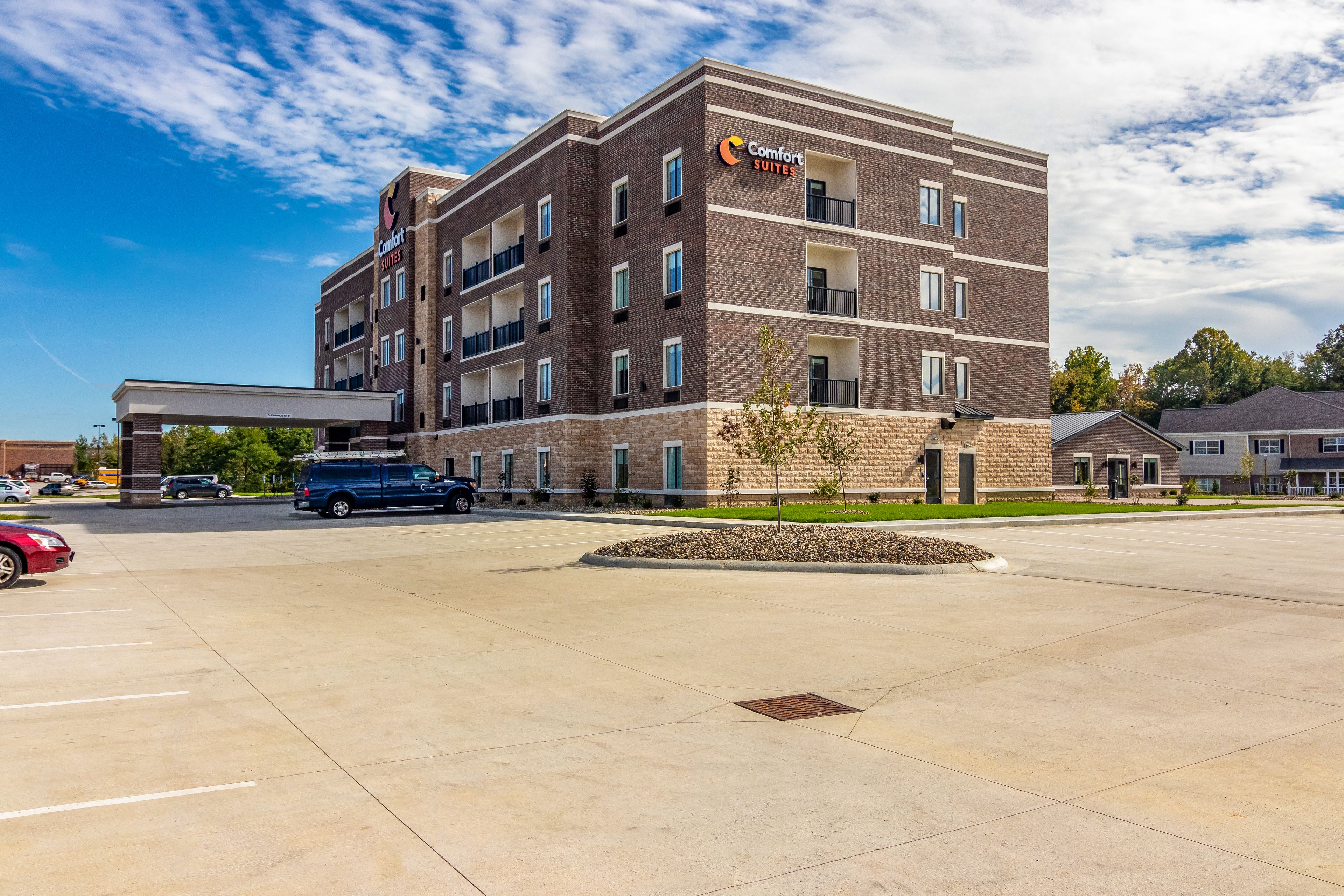 A Comfort Suites hotel with a brick exterior, multiple balconies, and a parking lot.