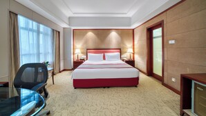 A hotel room with a large bed, a desk, and a chair. - Hangzhou Haiwaihai Communication Hotel (Hangzhou)