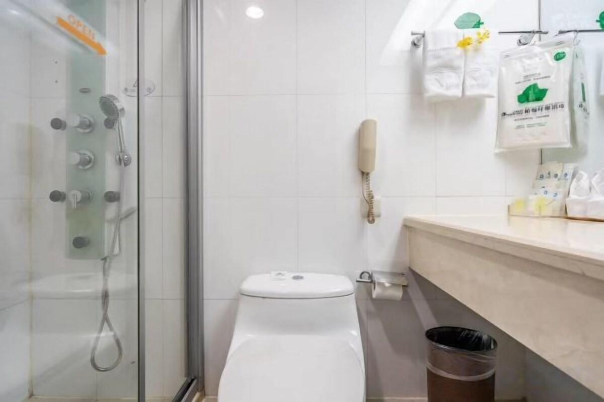 Un baño con ducha de vidrio, inodoro y lavamanos con espejo.