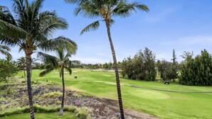 A golf course with palm trees, a well-maintained green, and a clear sky. - Waikoloa Beach S P32 2 Bedroom Villa by RedAwning (Waikoloa)
