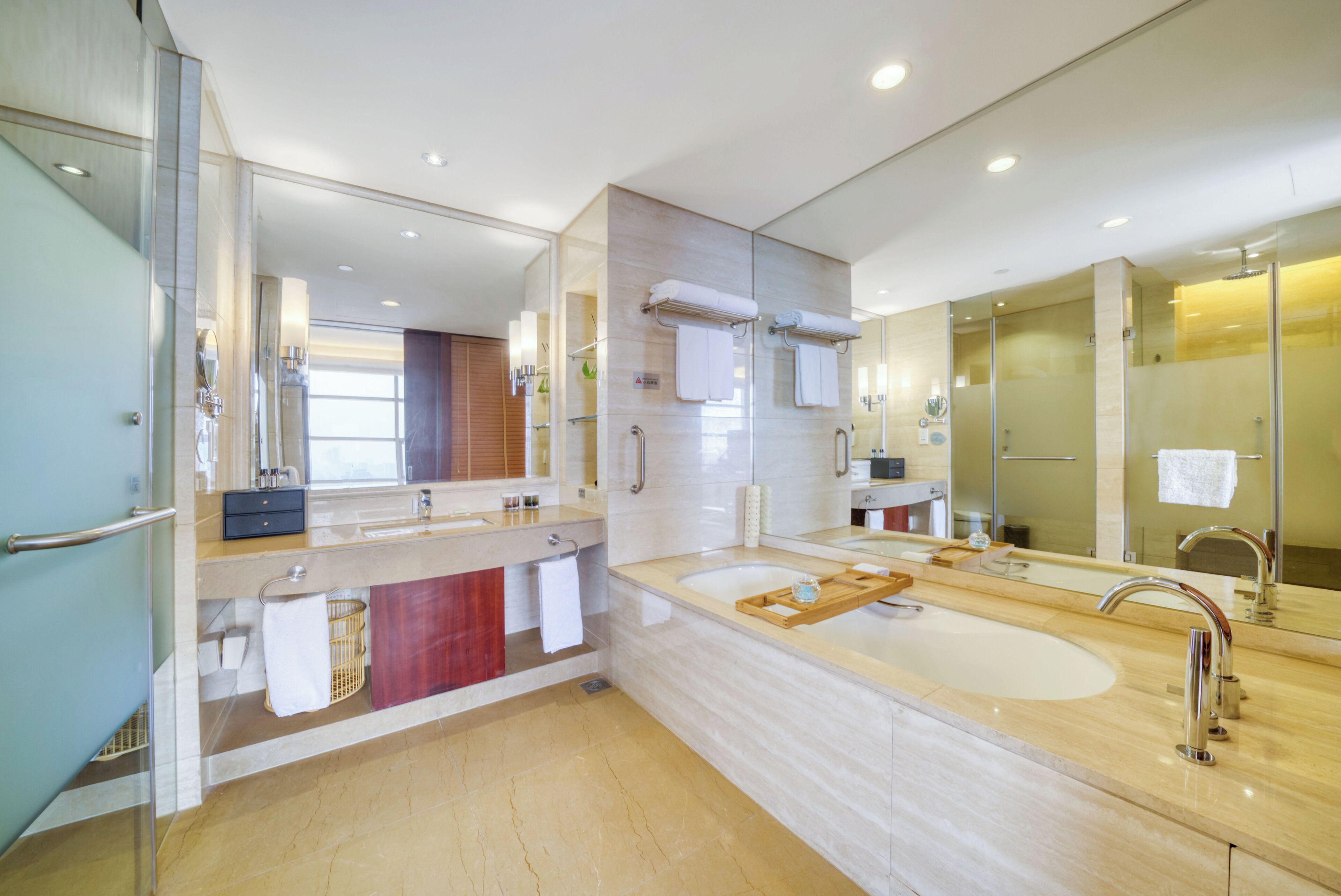 A modern bathroom with a large sink, a bathtub, and a glass-enclosed shower.