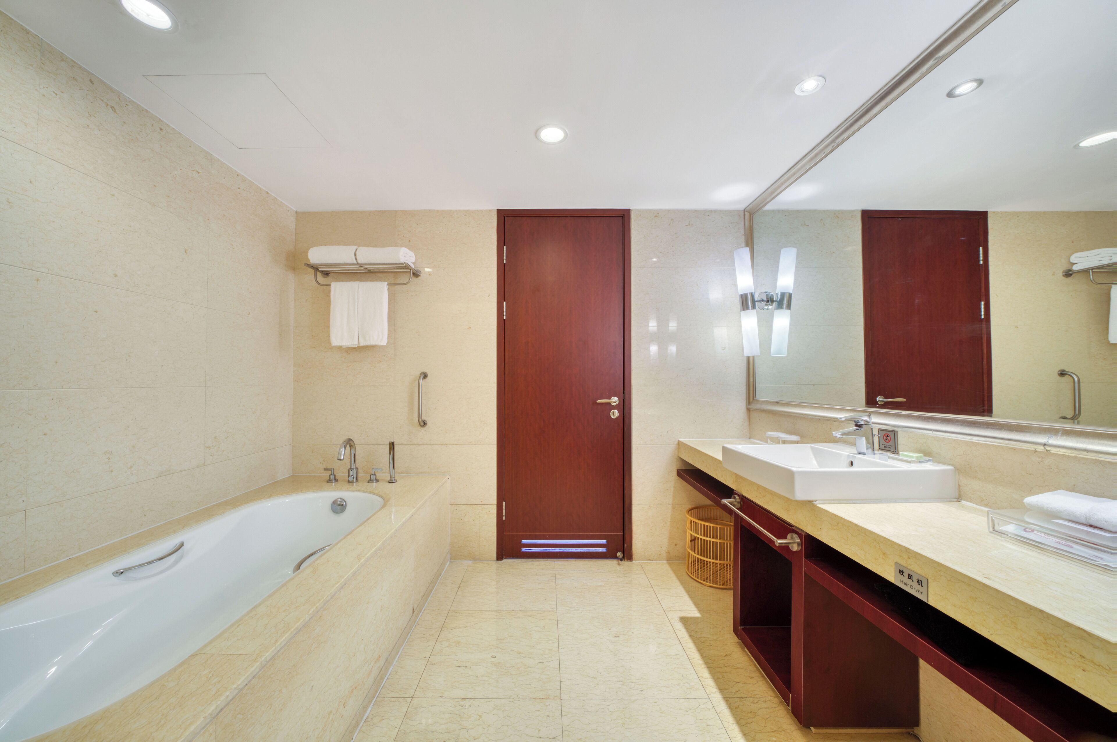 Un baño moderno con una bañera grande, dos lavamanos y un espejo.