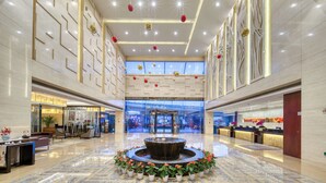 A spacious lobby with a central fountain, seating areas, and a reception desk. - Hangzhou Haiwaihai Hotel (Hangzhou)