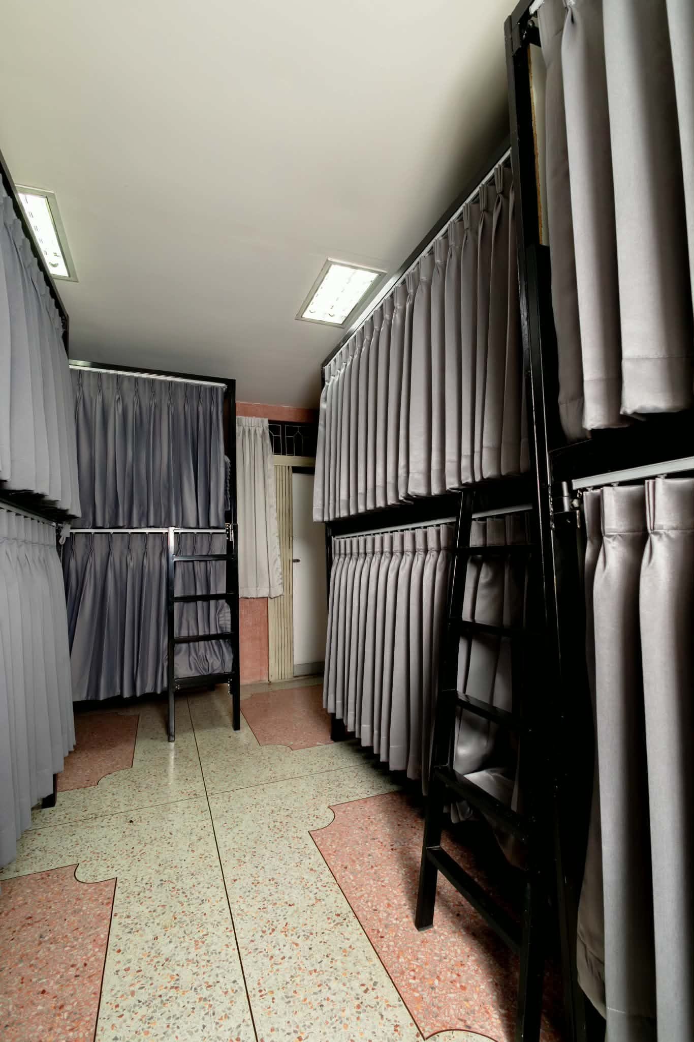 A room with bunk beds, a door, and a tiled floor.