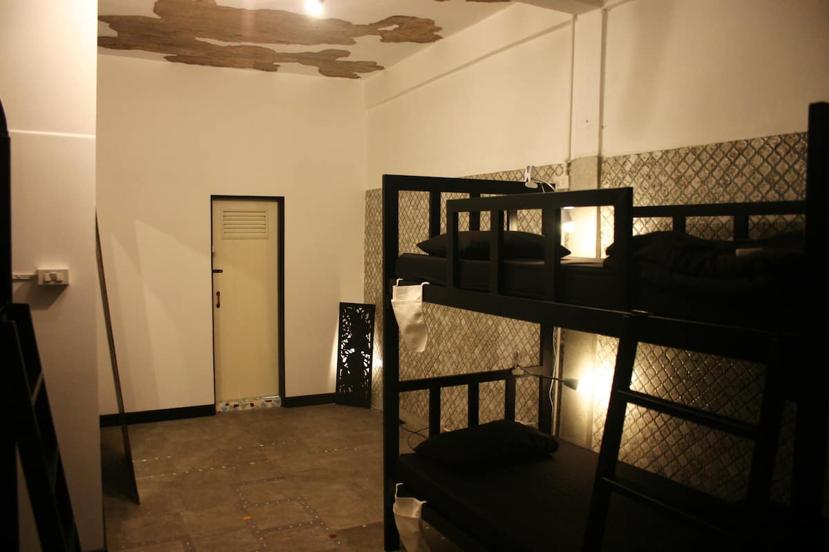 A bunk bed room with a door and a patterned wall.