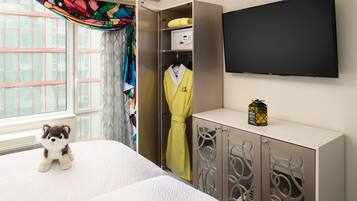 Ein Hotelzimmer mit Bett, Kleiderschrank, Fernseher und einem fenster mit Vorhängen.