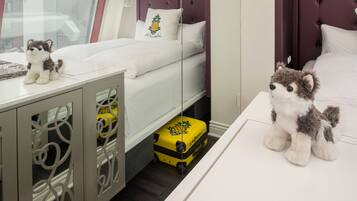 Una habitación de hotel con cama, tocador, espejo y maleta.
