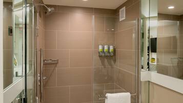 A modern bathroom with a glass-enclosed shower, a glass door, and a towel rack.