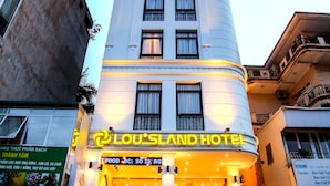 A hotel with a curved facade, multiple windows, and a sign reading "Lou's Land Hotel". - Louisland Hotel (Hanoi)