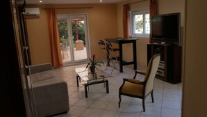 A living room with a sofa, a coffee table, a TV, and a dining table with chairs. - Villa Seignemartin (Lyon)