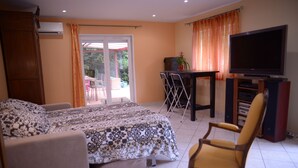 A bedroom with a bed, a chair, a TV, and a desk. - Villa Seignemartin (Lyon)