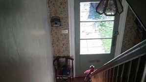 A staircase with a wooden handrail leading to a door with a window. - Winton House (Stratford-upon-Avon)