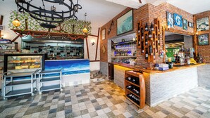 Angolo bar con pavimento a scacchi, una cantina e un bancone con vetrina.