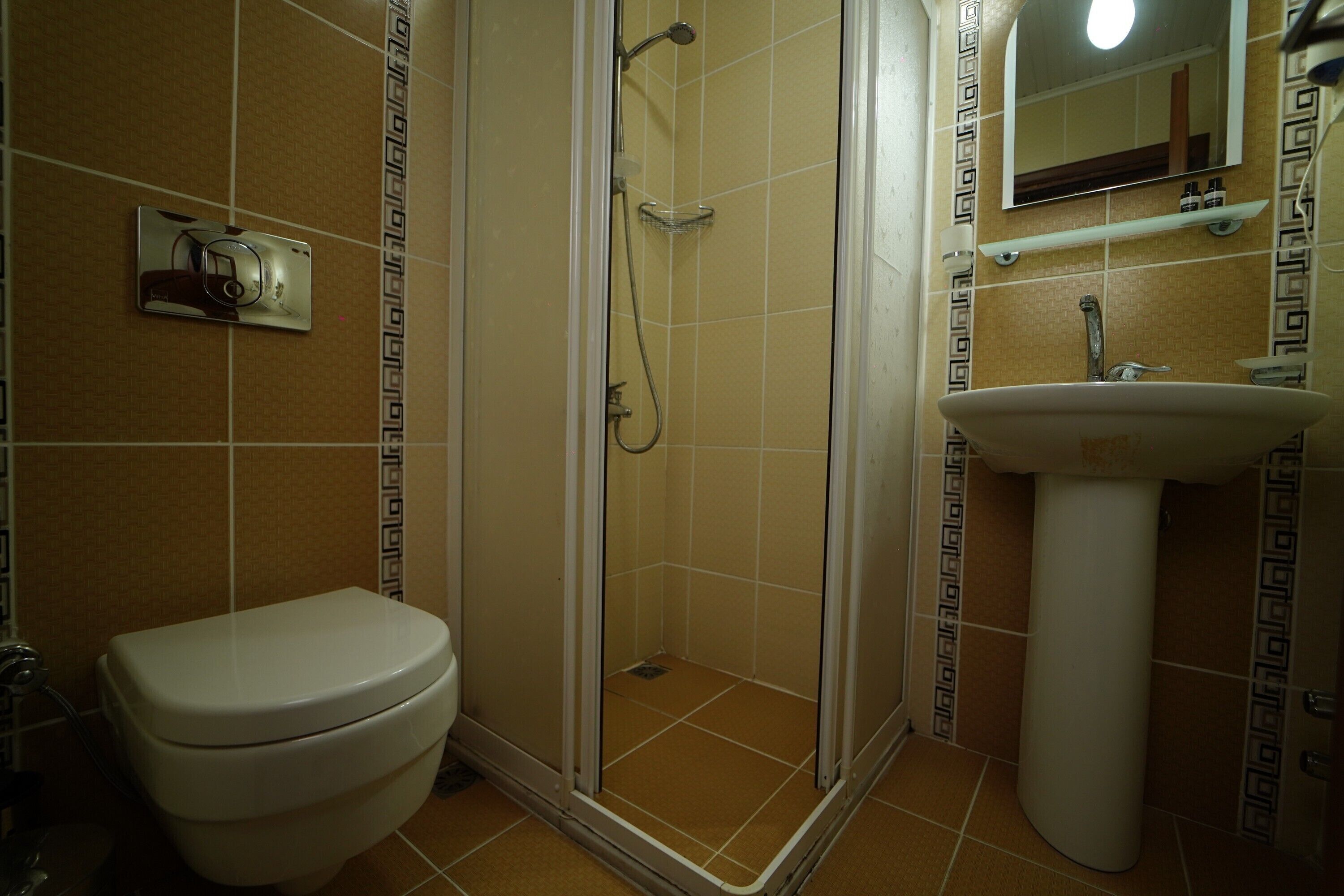 A bathroom with a toilet, a shower enclosure, and a sink.
