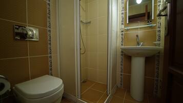 Un baño con inodoro, ducha y lavamanos.