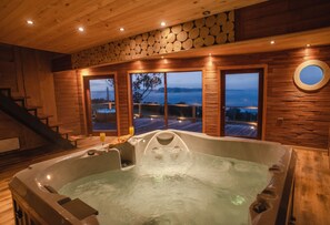 Un jacuzzi en una cabaña de madera con vista al agua.
