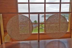Una habitación con un ventanal grande que tiene un diseño de cuadrícula y dos adornos metálicos circulares.