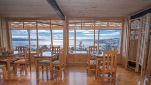 Un comedor de madera con vistas a un lago y montañas.