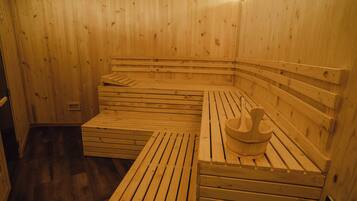 A sauna room with wooden benches and a wooden basin.