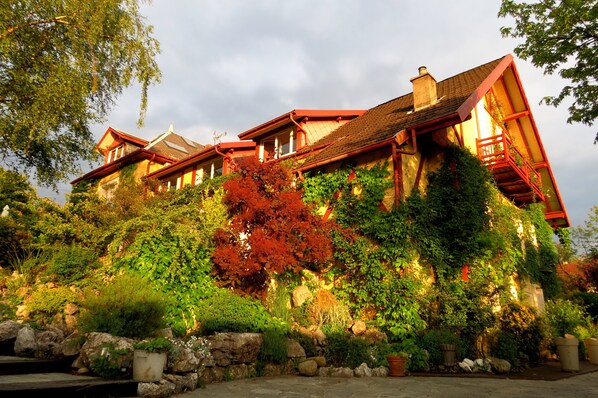 A large, multi-story building with a red roof and extensive ivy coverage. - Demeure d'Hôtes L'Hermitage (Aix-les-Bains)