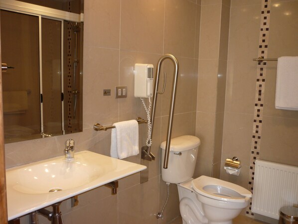 A modern bathroom with a sink, toilet, and shower.