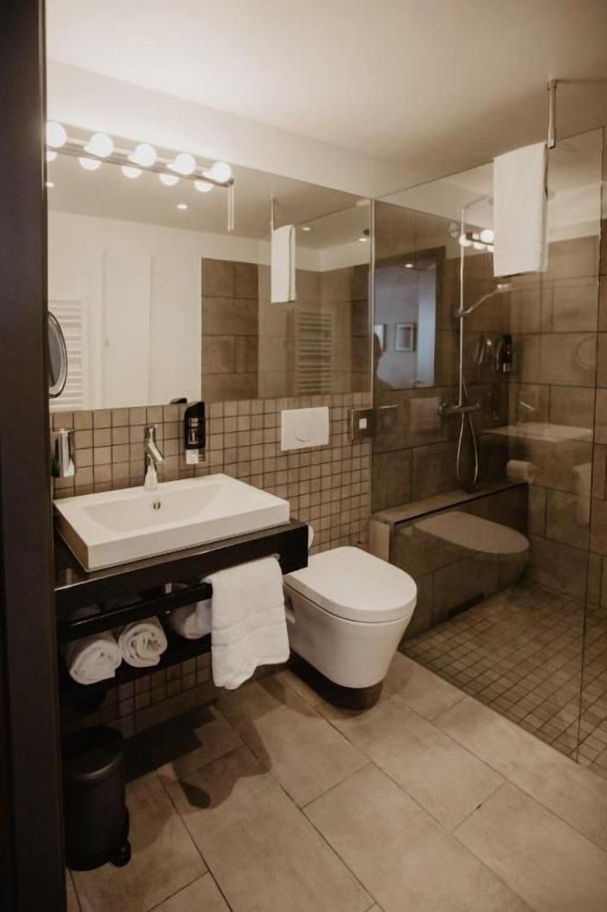 A modern bathroom with a sink, toilet, and shower area.